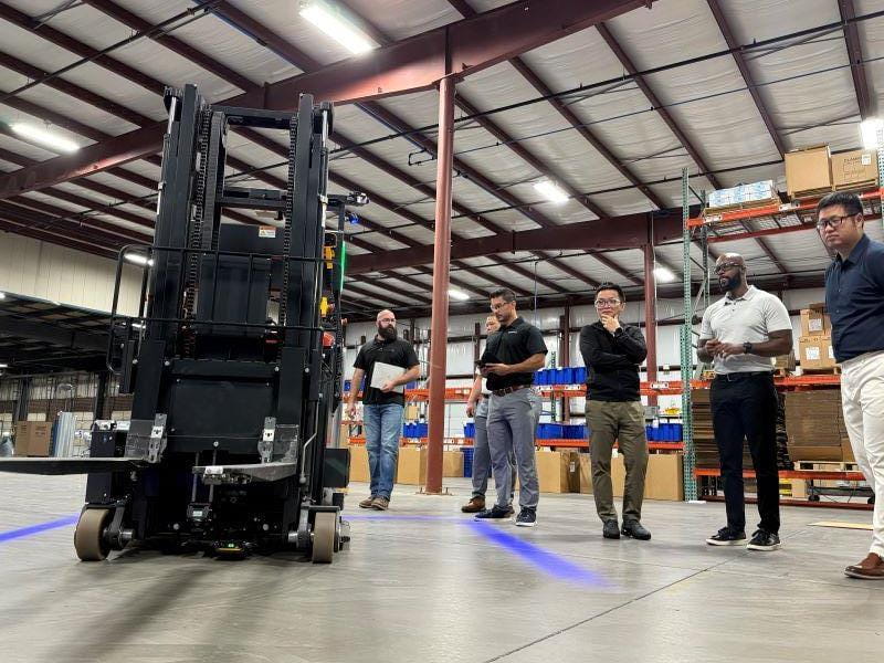 group looking at forklift